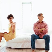 couple sitting on the bed, arguing