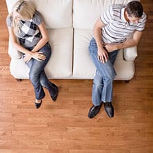 couple sitting on couch, turning away from each other